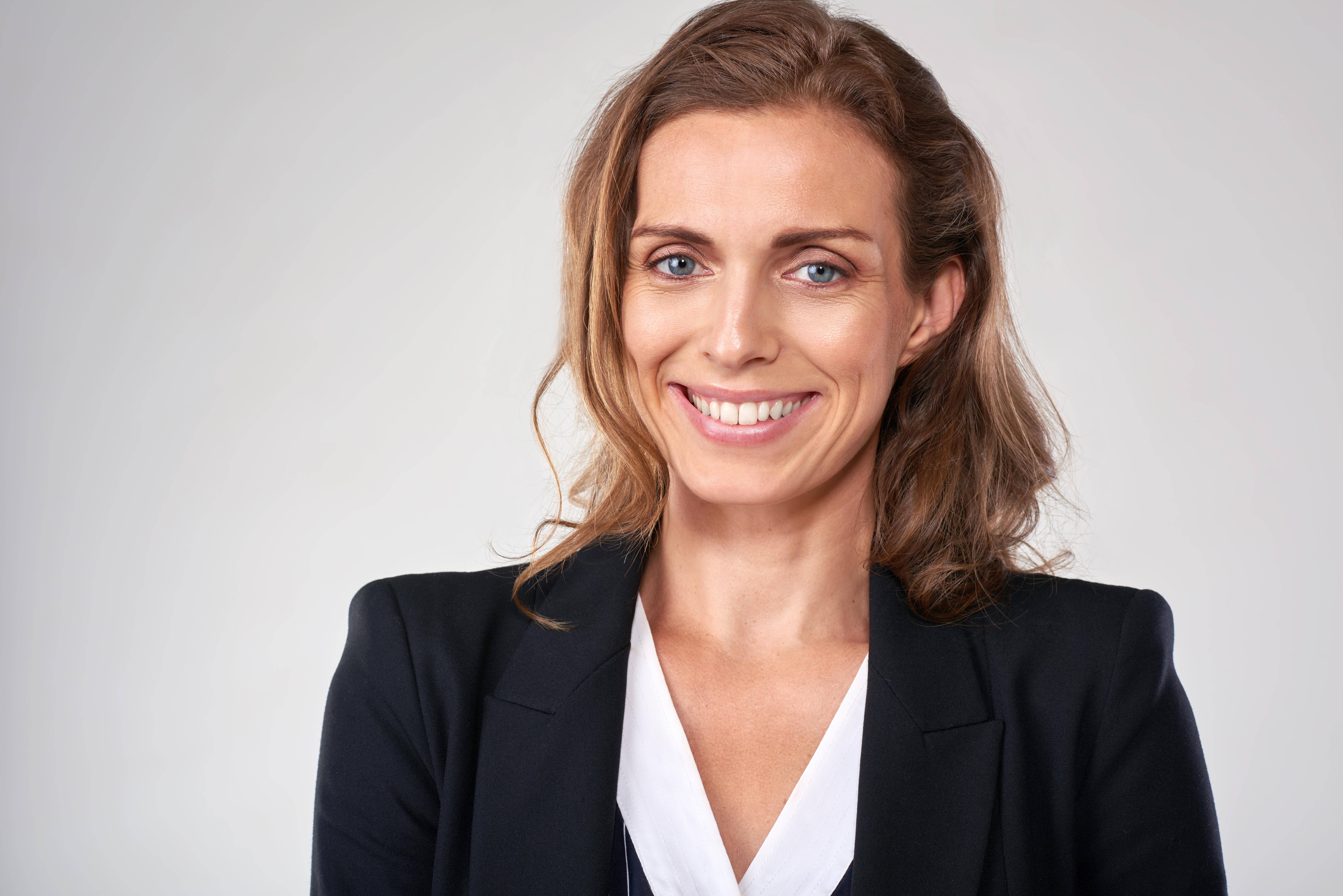 Headshot of middle age business woman in studio, isolated on grey